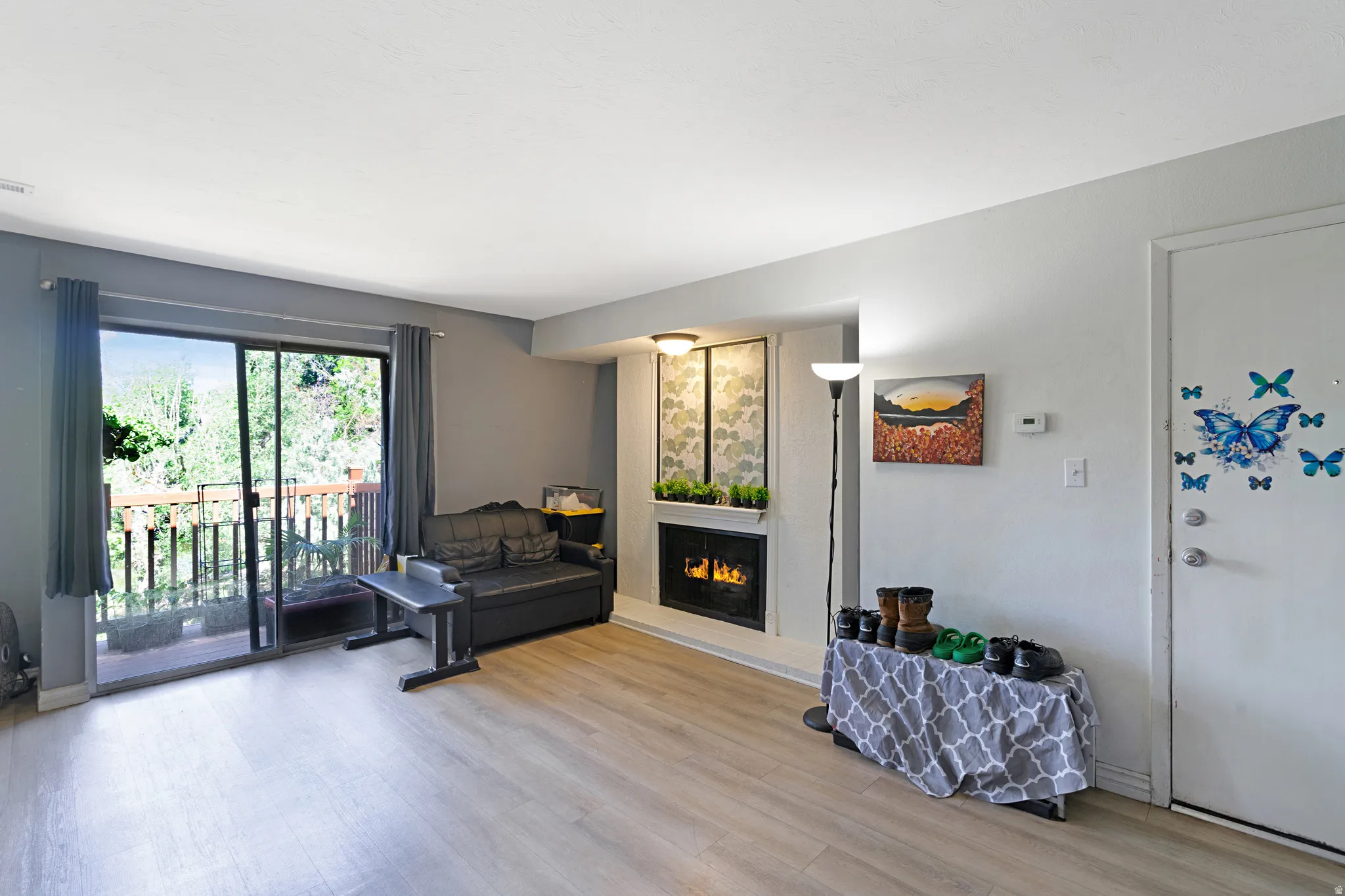 Spacious interior with wood-finish flooring, a built-in fireplace, and sliding glass doors opening to a private balcony