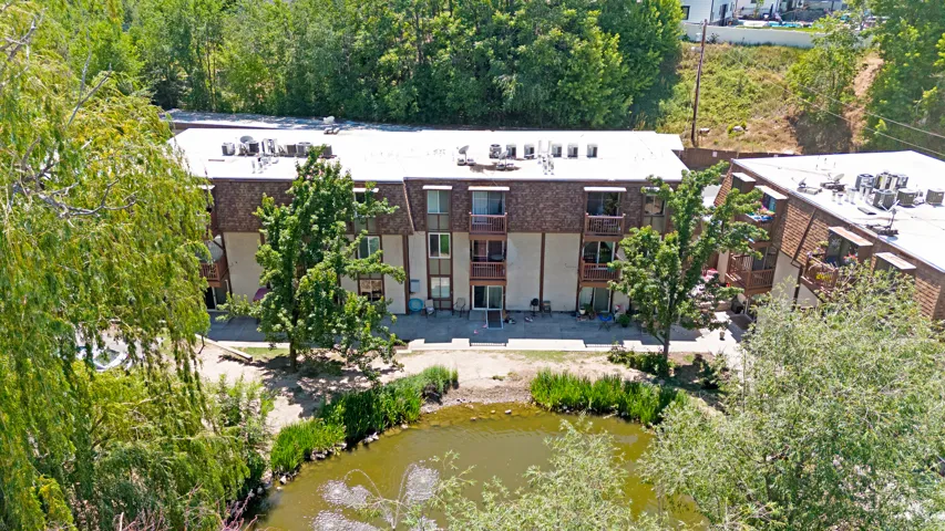 Three-story multi-unit building featuring individual balconies and patios