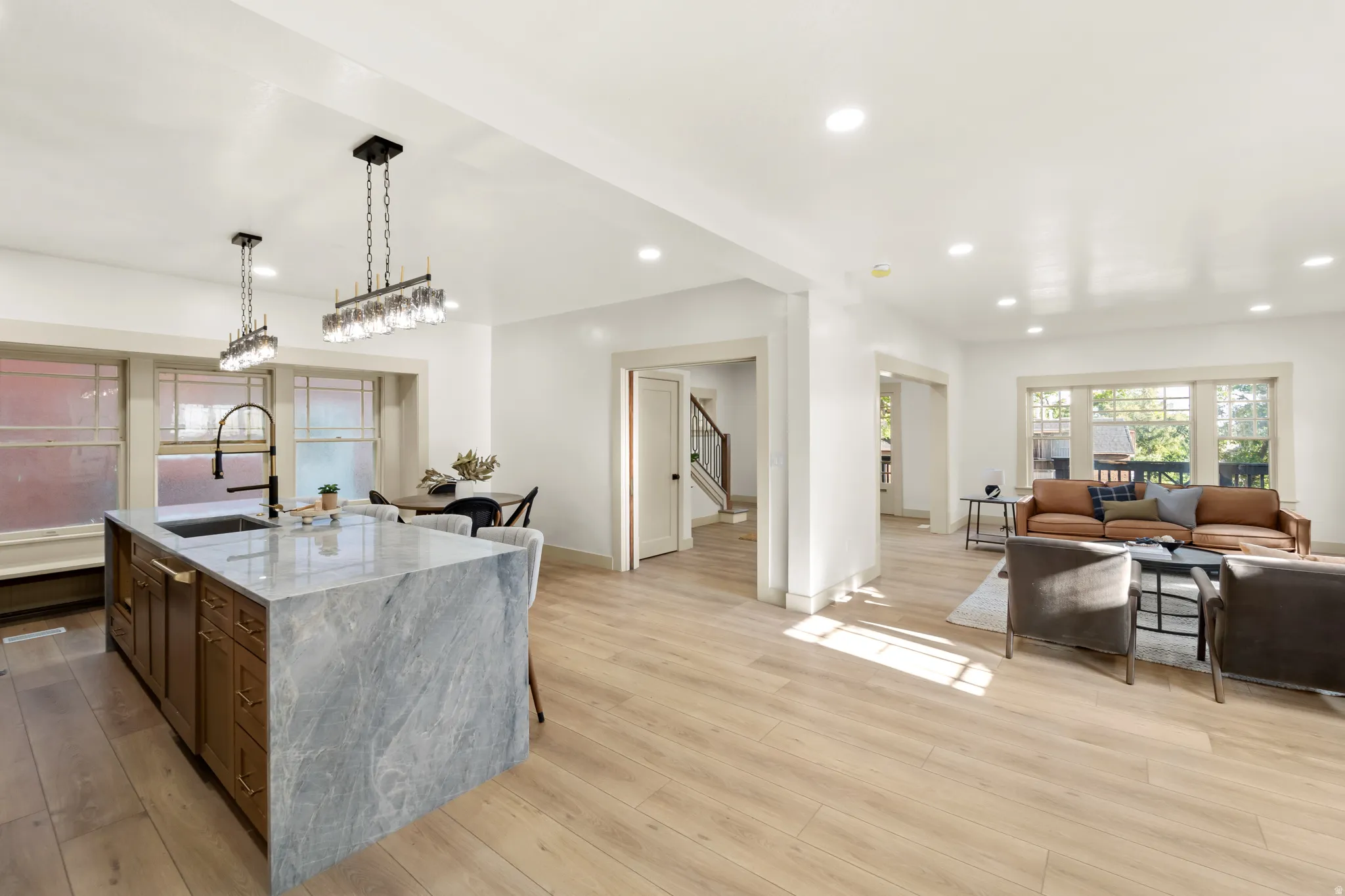 Open-concept living space featuring a substantial kitchen island with a stone countertop and integrated sink