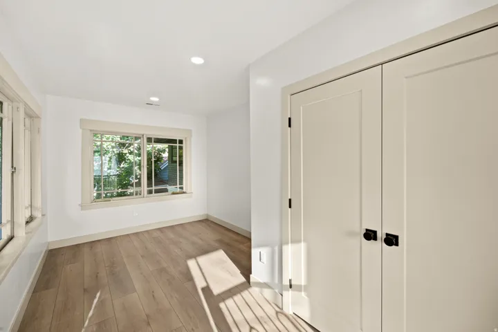 Room featuring wood-finish flooring, recessed lighting, and white walls