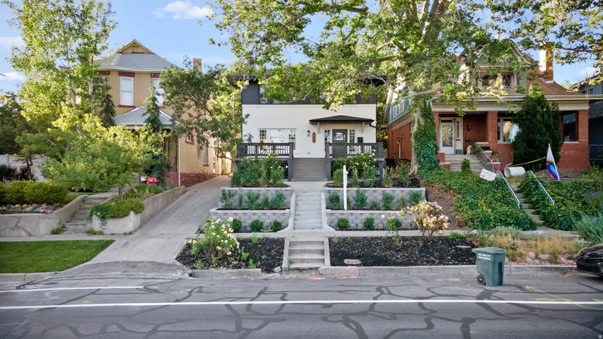 Modern exterior featuring a prominent elevated deck, contemporary black railing, and a minimalist entryway