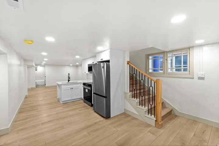 Open-concept living space with wood-finish flooring and recessed lighting