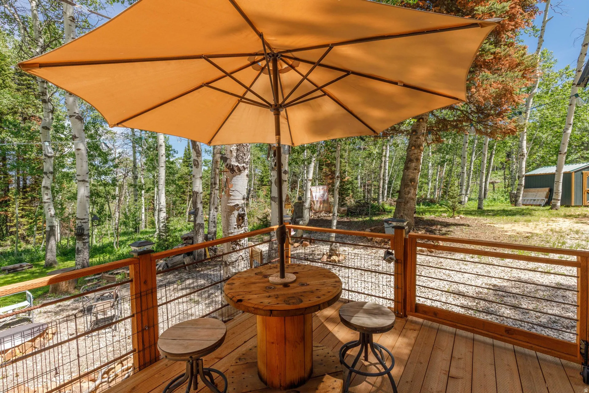 Expansive outdoor deck featuring wood flooring and a sturdy cable railing system