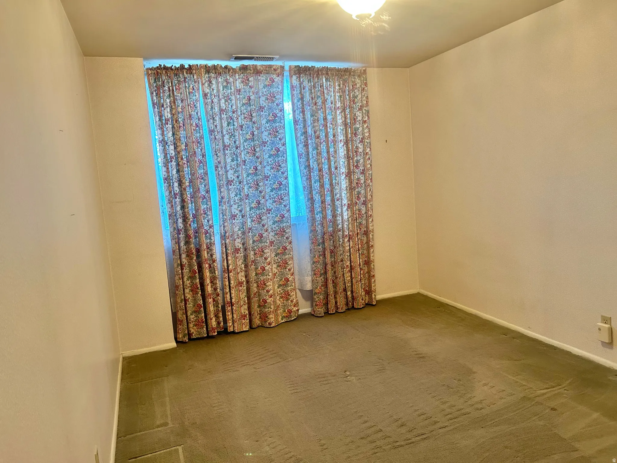 Bedroom featuring broadloom carpeting and window treatments