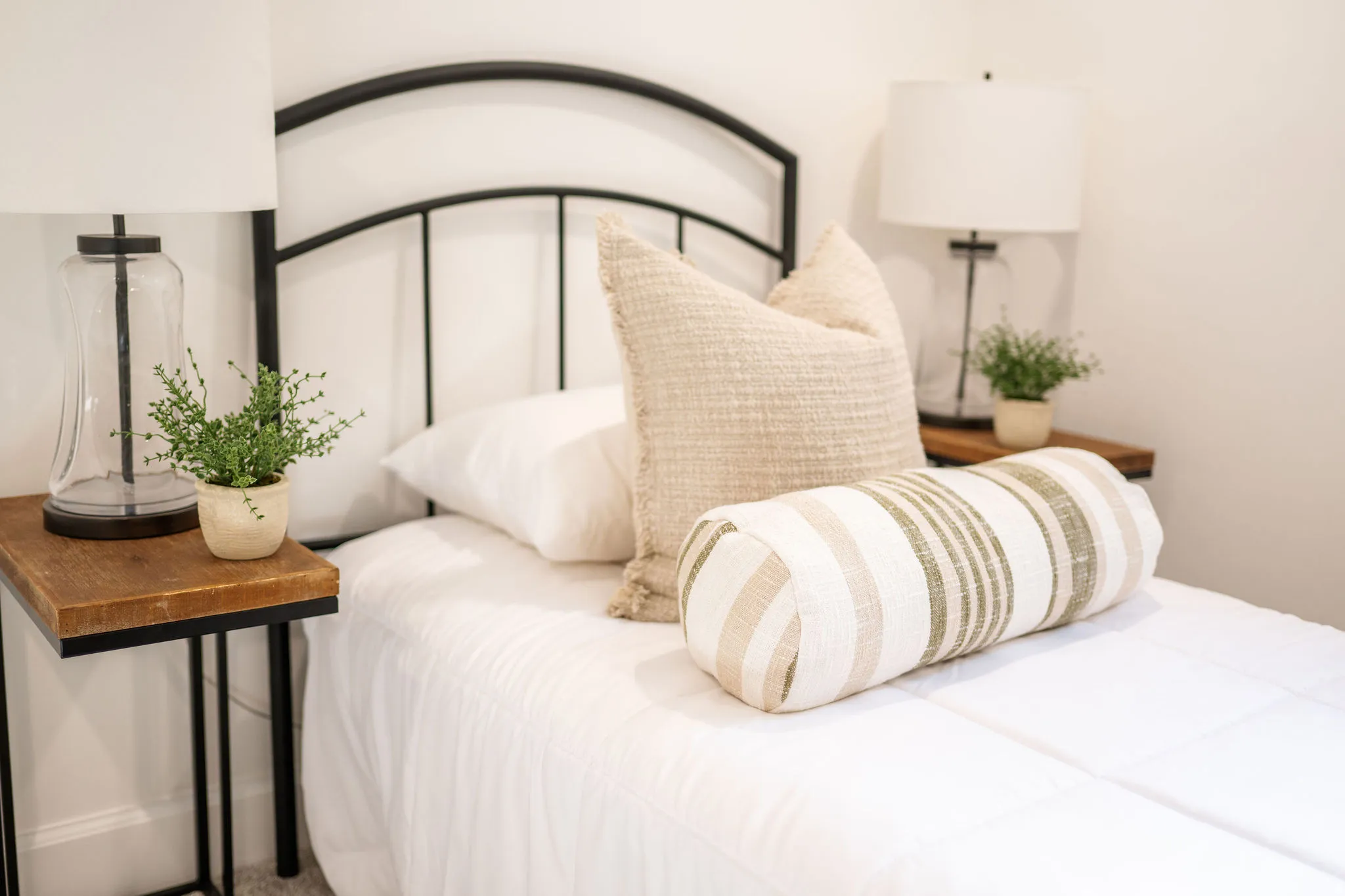 Bedroom featuring a black metal bed frame with matching wood-finish top side tables