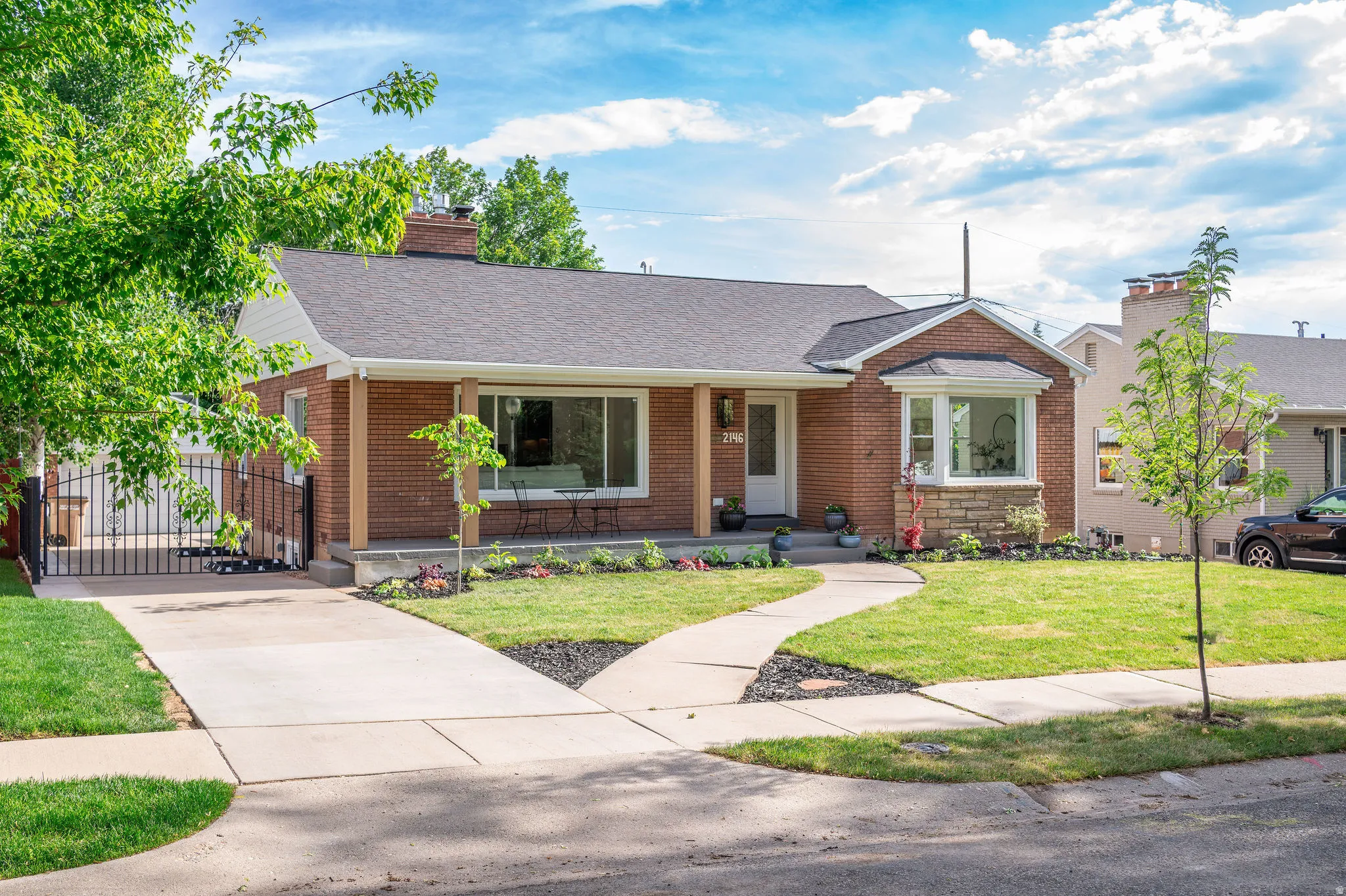 Brick facade residence with a dark shingle roof and white trim accents