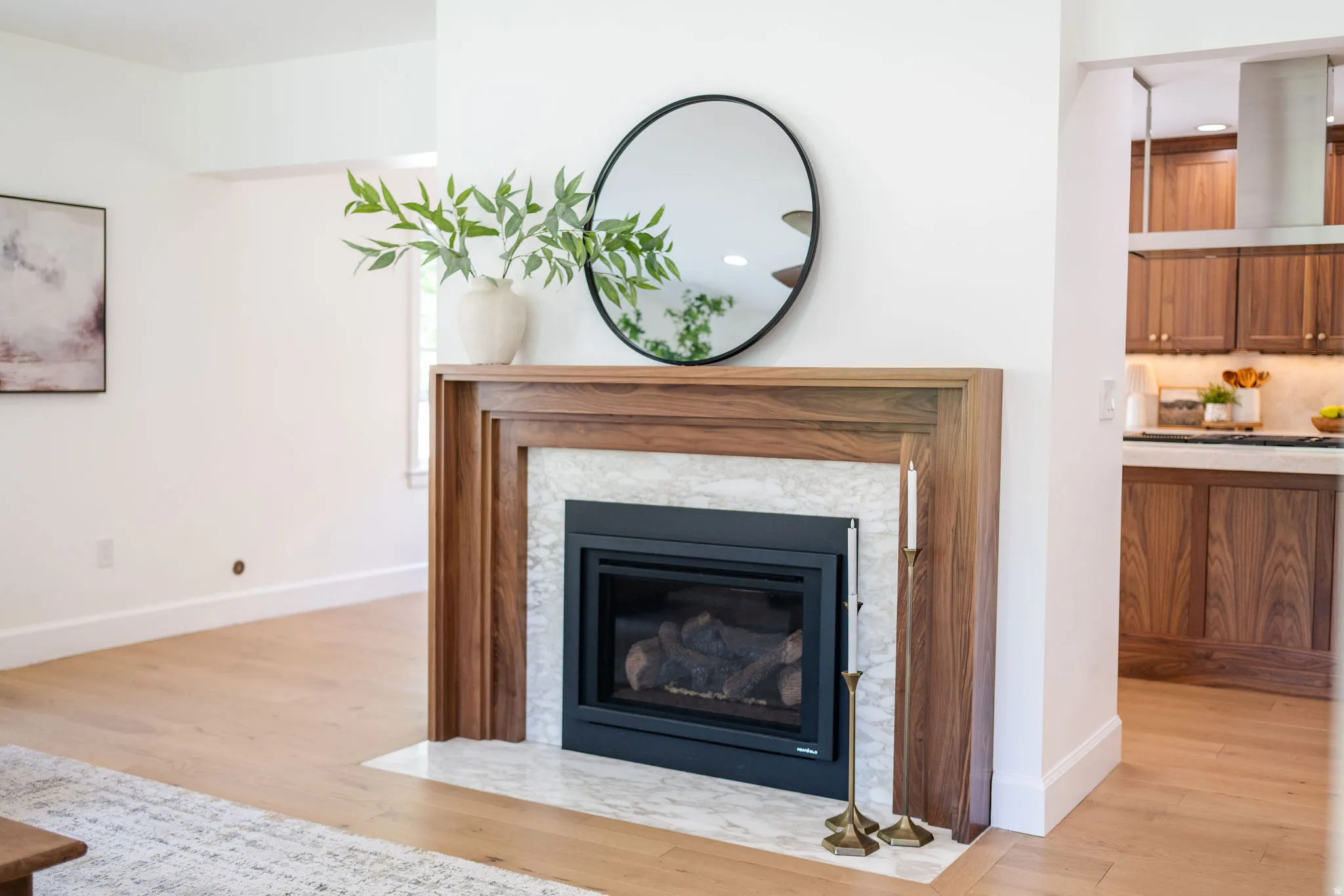 Wood-finish fireplace mantel with a marble-style surround and a black hearth