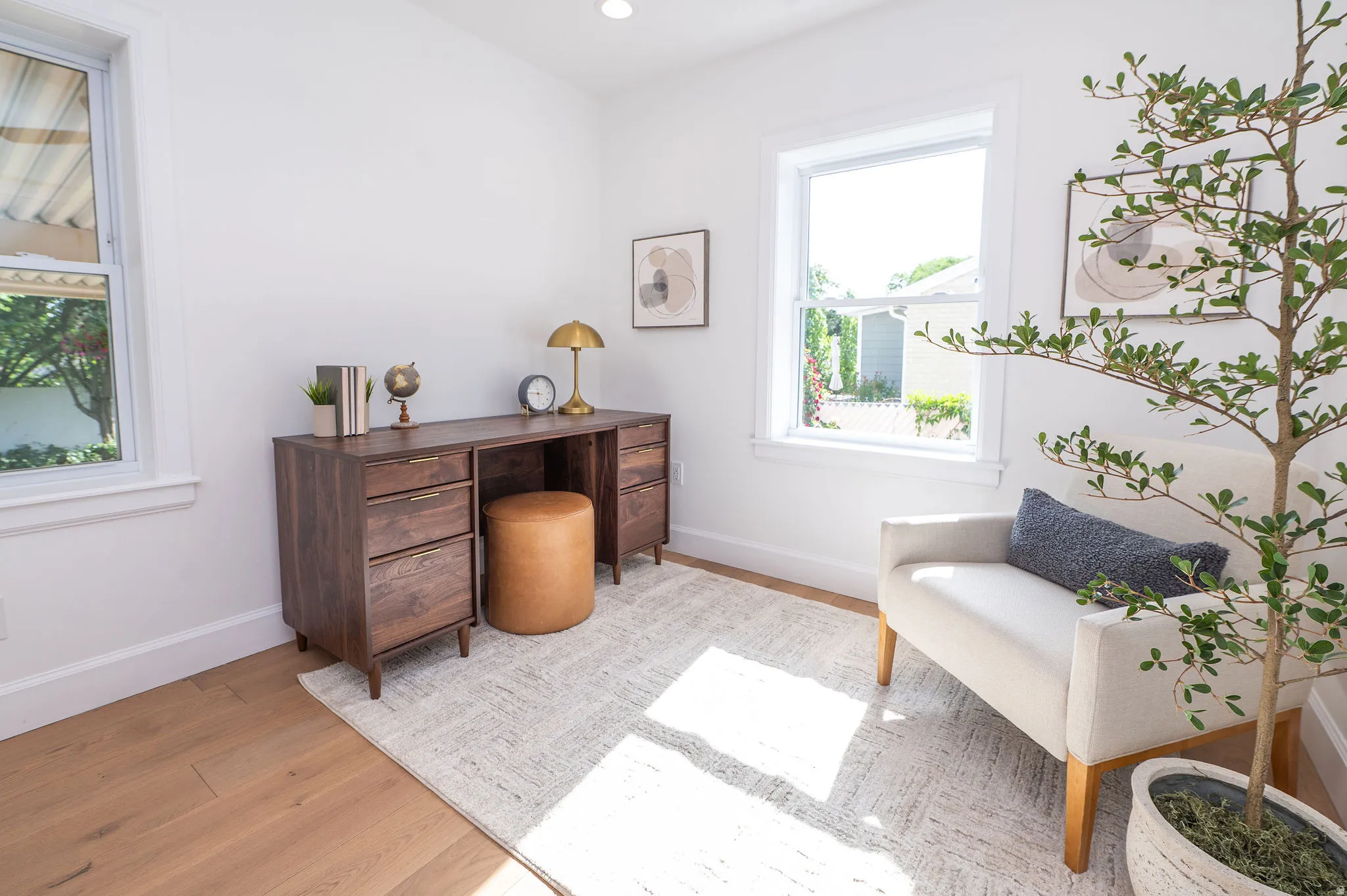 Light-filled room featuring hardwood flooring, crisp white walls, and recessed lighting
