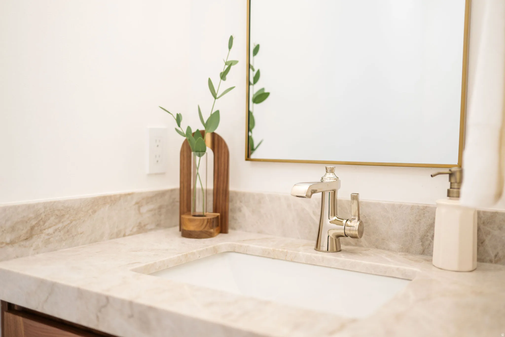 White countertop with subtle veining, undermount sink, and brushed nickel faucet