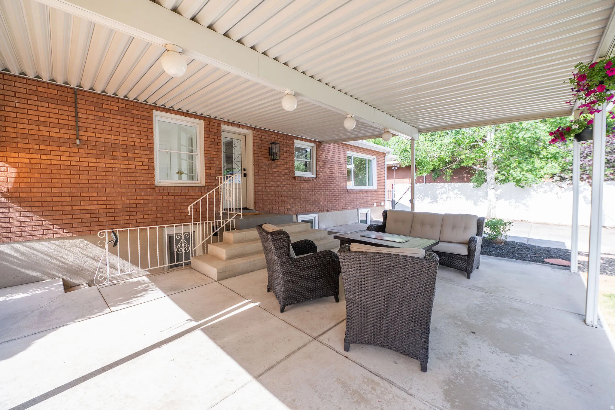 Covered patio with concrete flooring, recessed lighting, and a brick exterior wall