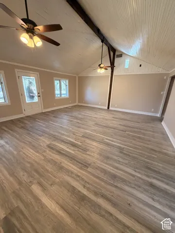 Vaulted wood-paneled ceiling with exposed wood beams, wood-finish flooring, and multiple ceiling fans