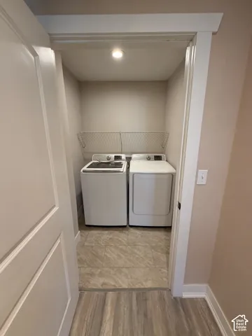Recessed lighting illuminates the laundry area featuring tile flooring, a built-in wire rack, and classic white trim