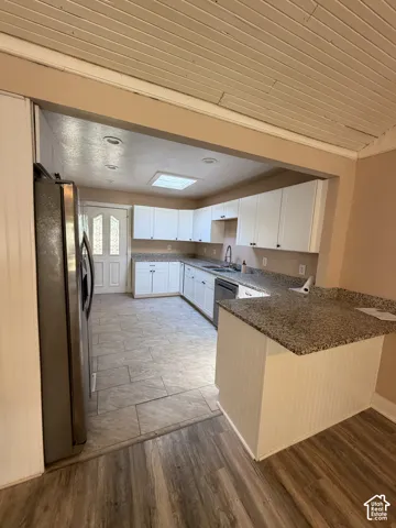 Kitchen featuring white cabinetry, granite countertops, tile flooring, and recessed lighting