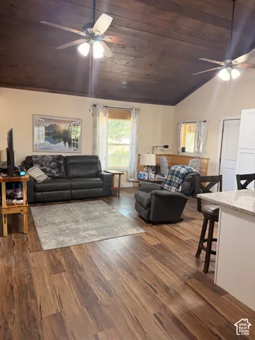 Vaulted wood-paneled ceiling with two ceiling fans, wood-finish flooring, and light-toned wall paint