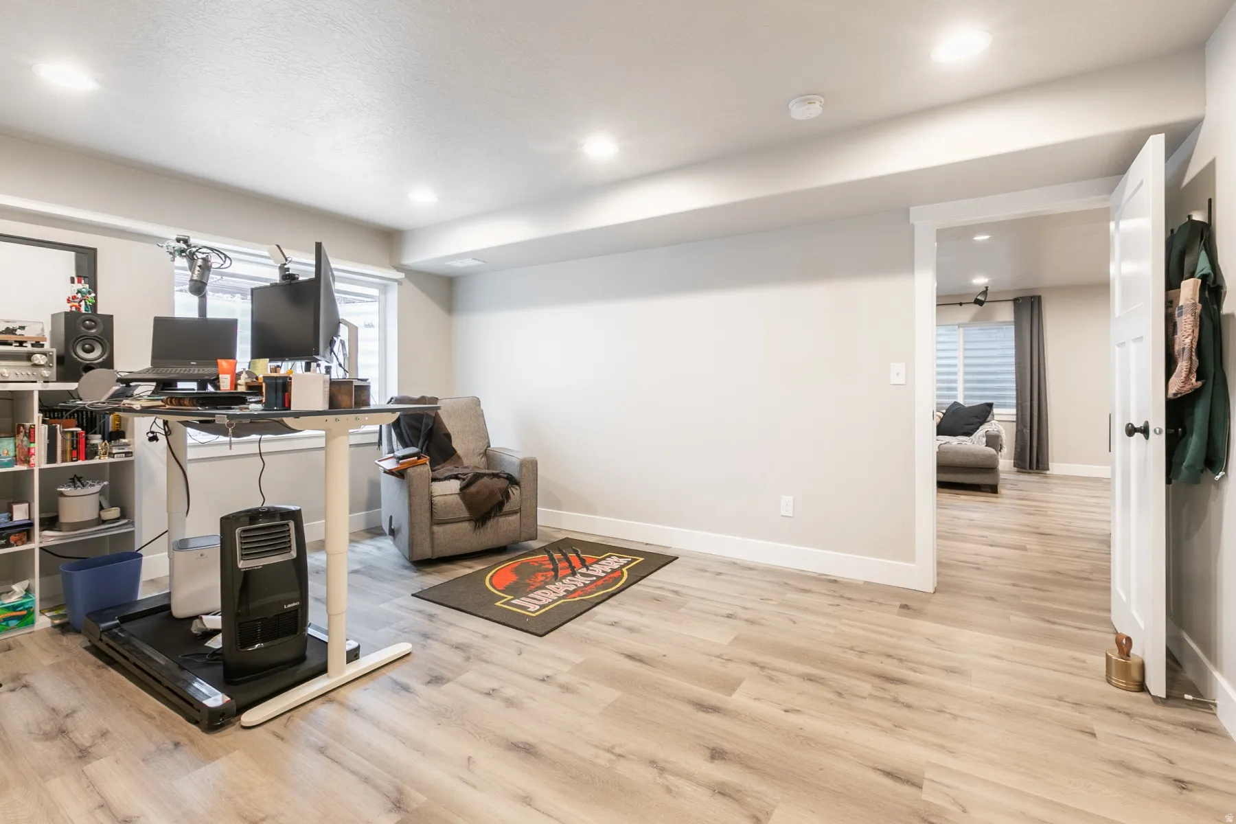Spacious room featuring wood-finish flooring, recessed lighting, and neutral wall tones