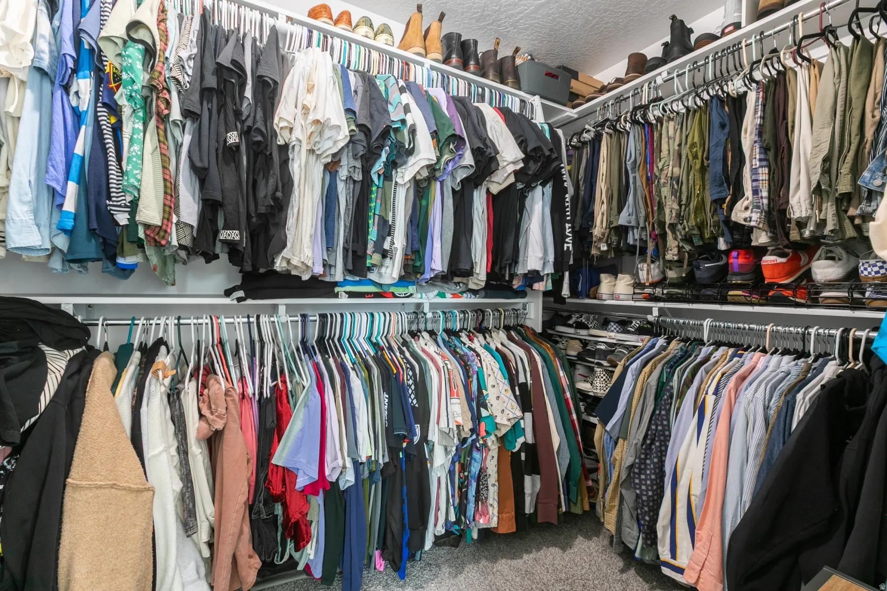 Walk-in closet featuring extensive built-in shelving, multiple hanging rods, and corner storage solutions