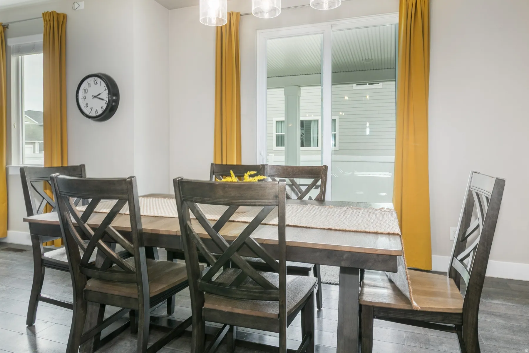 Formal dining space featuring wood-finish flooring, white walls, and a sliding glass door to the exterior