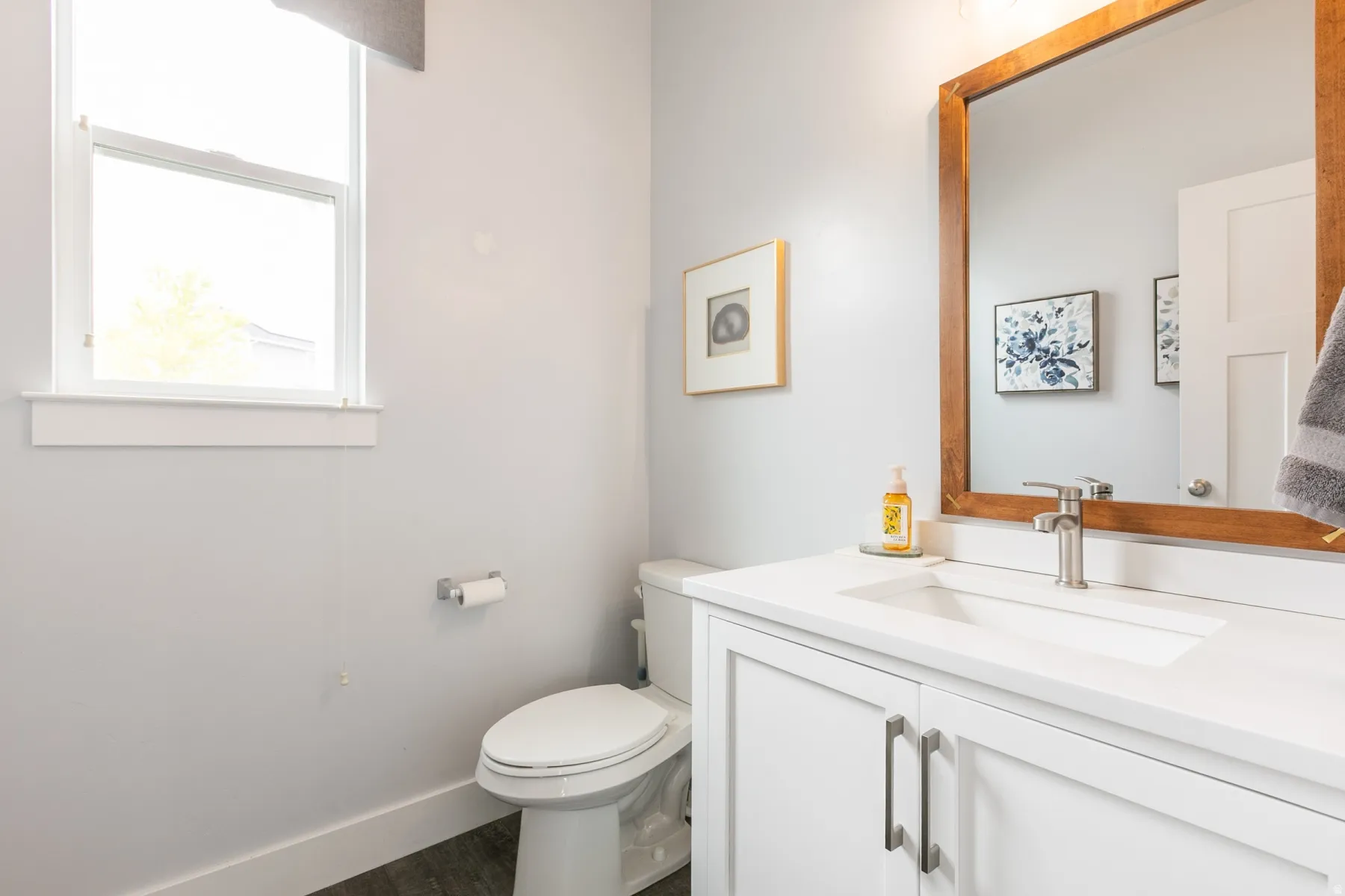 Bathroom vanity featuring a white countertop, undermount sink, and brushed nickel faucet