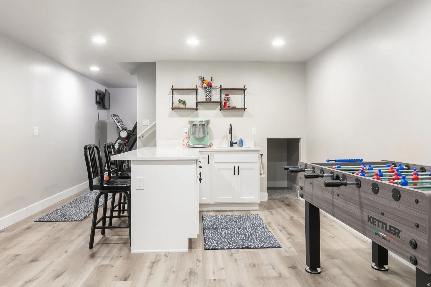 Recessed lighting illuminating a spacious room with wood-finish flooring