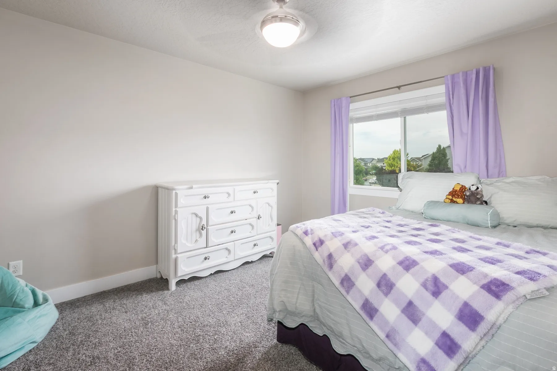 Room featuring a large window, neutral wall paint, and gray carpet flooring