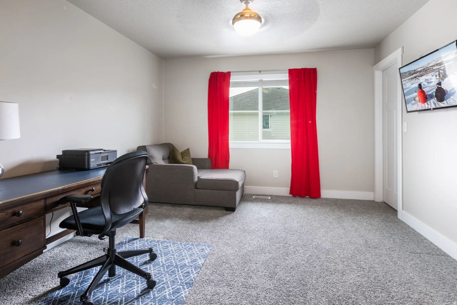 Carpeted interior room featuring light-colored walls and a window with white trim