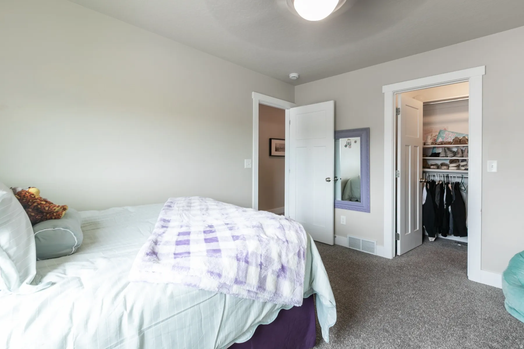 Bedroom featuring neutral wall paint, gray carpet flooring, a white ceiling fan with integrated lighting, and white trim