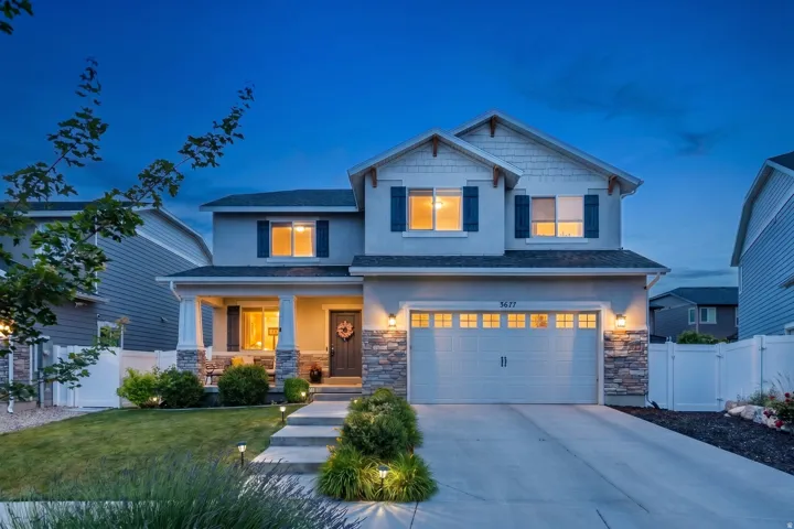 Two-story residence featuring a stone and stucco exterior