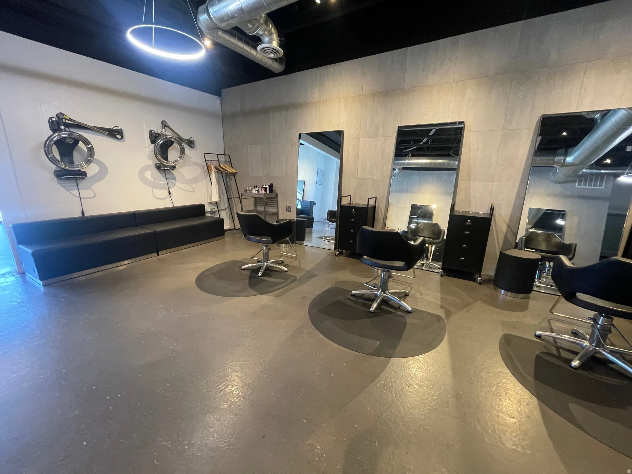 Open commercial space featuring exposed ceiling ductwork and a dark finished concrete floor