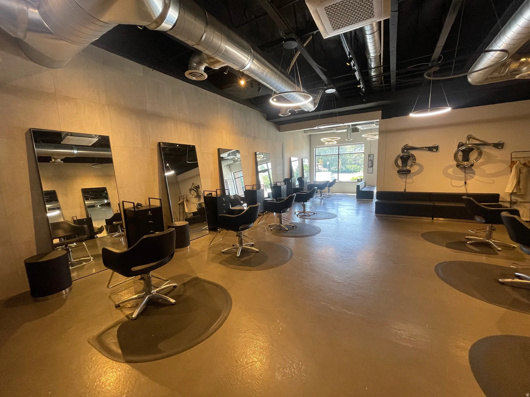 Open commercial space featuring exposed ceiling ductwork and track lighting