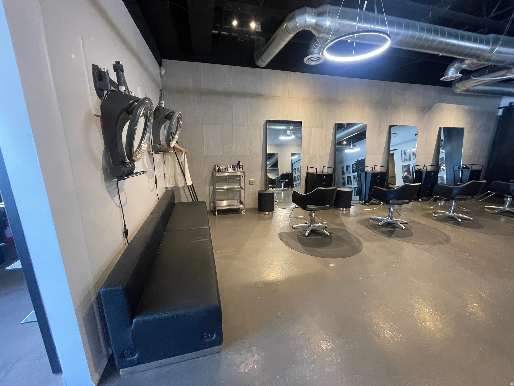 Commercial interior featuring concrete flooring, exposed ductwork, and track lighting