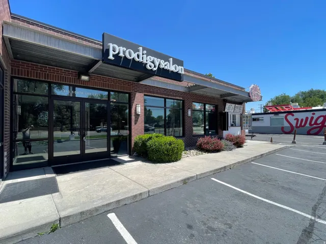 Commercial storefront featuring a brick facade with large display windows and a prominent awning