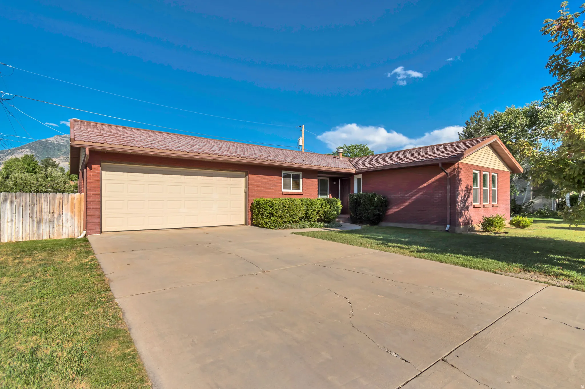Brick exterior featuring a multi-pane garage door and a concrete driveway