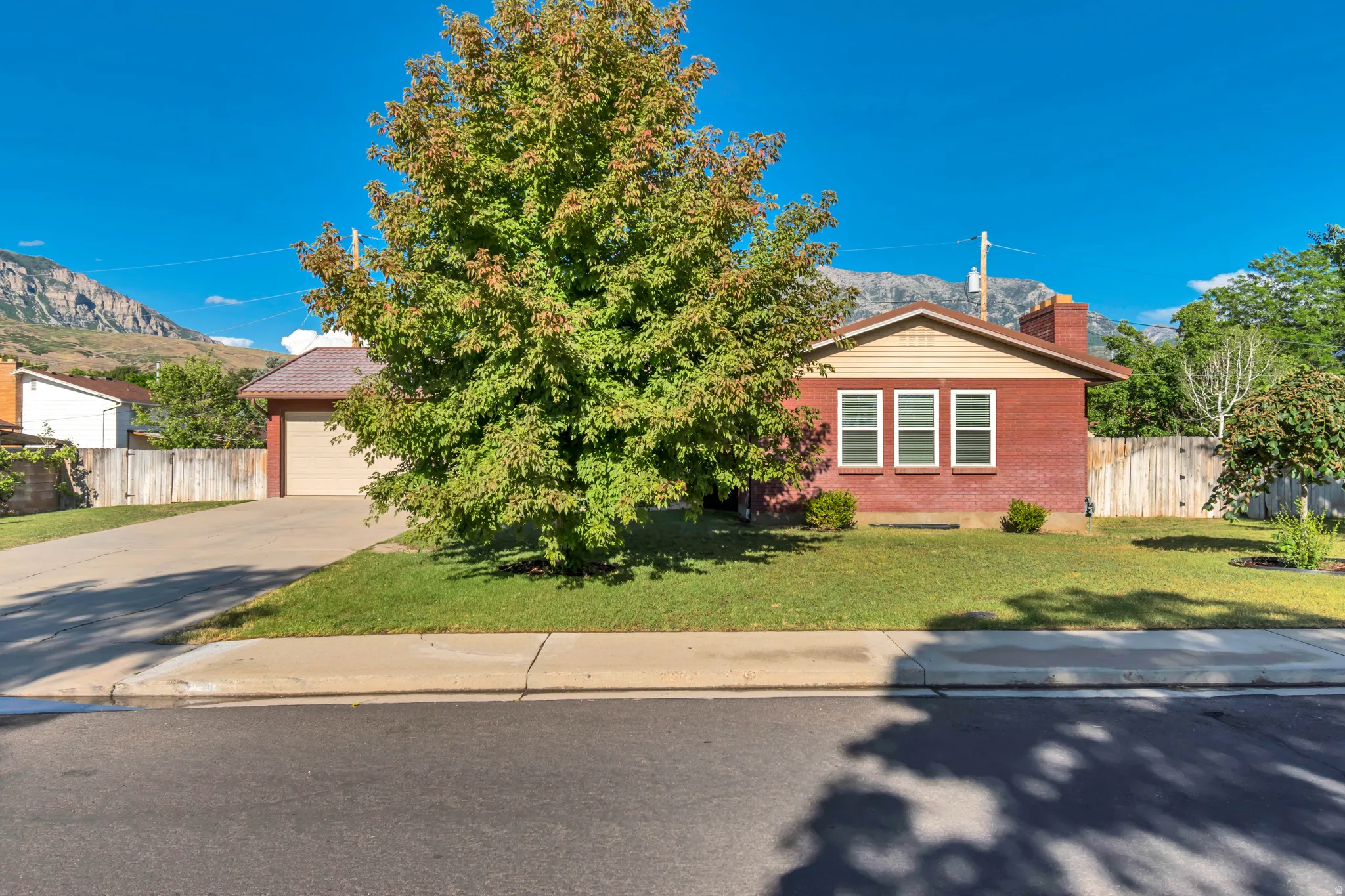 Red brick exterior featuring a light-colored gable, three front-facing windows, and a prominent chimney