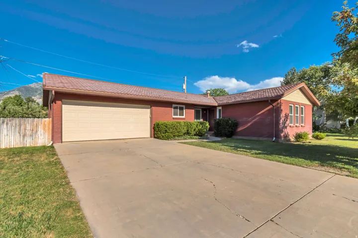 Brick exterior featuring a multi-pane garage door and a concrete driveway