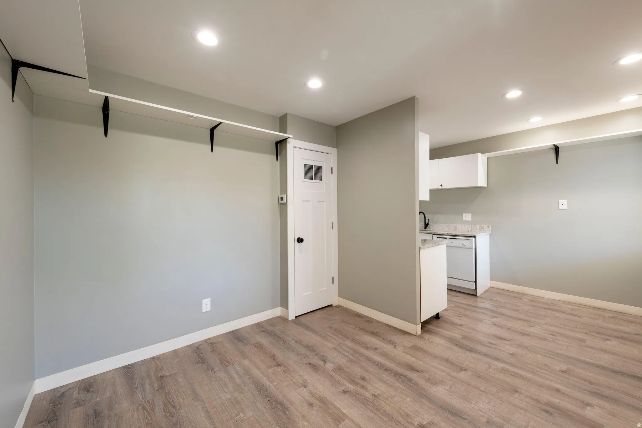 Open living area featuring wood-finish flooring, recessed lighting, and a neutral wall color