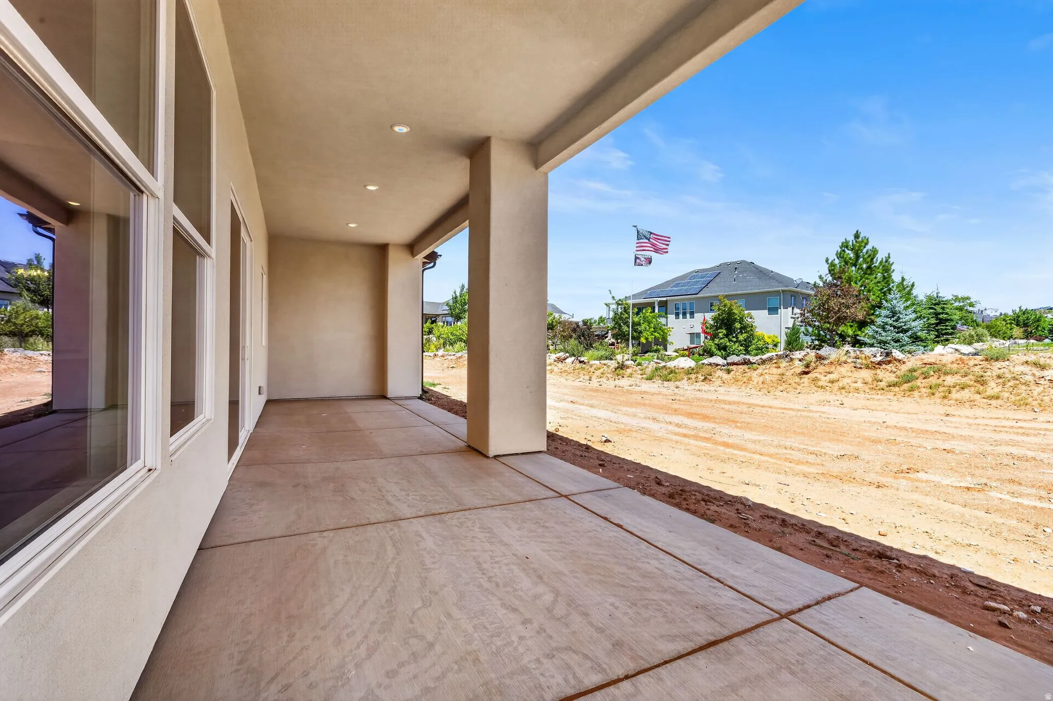 Spacious covered patio with recessed lighting, large windows, and a concrete surface