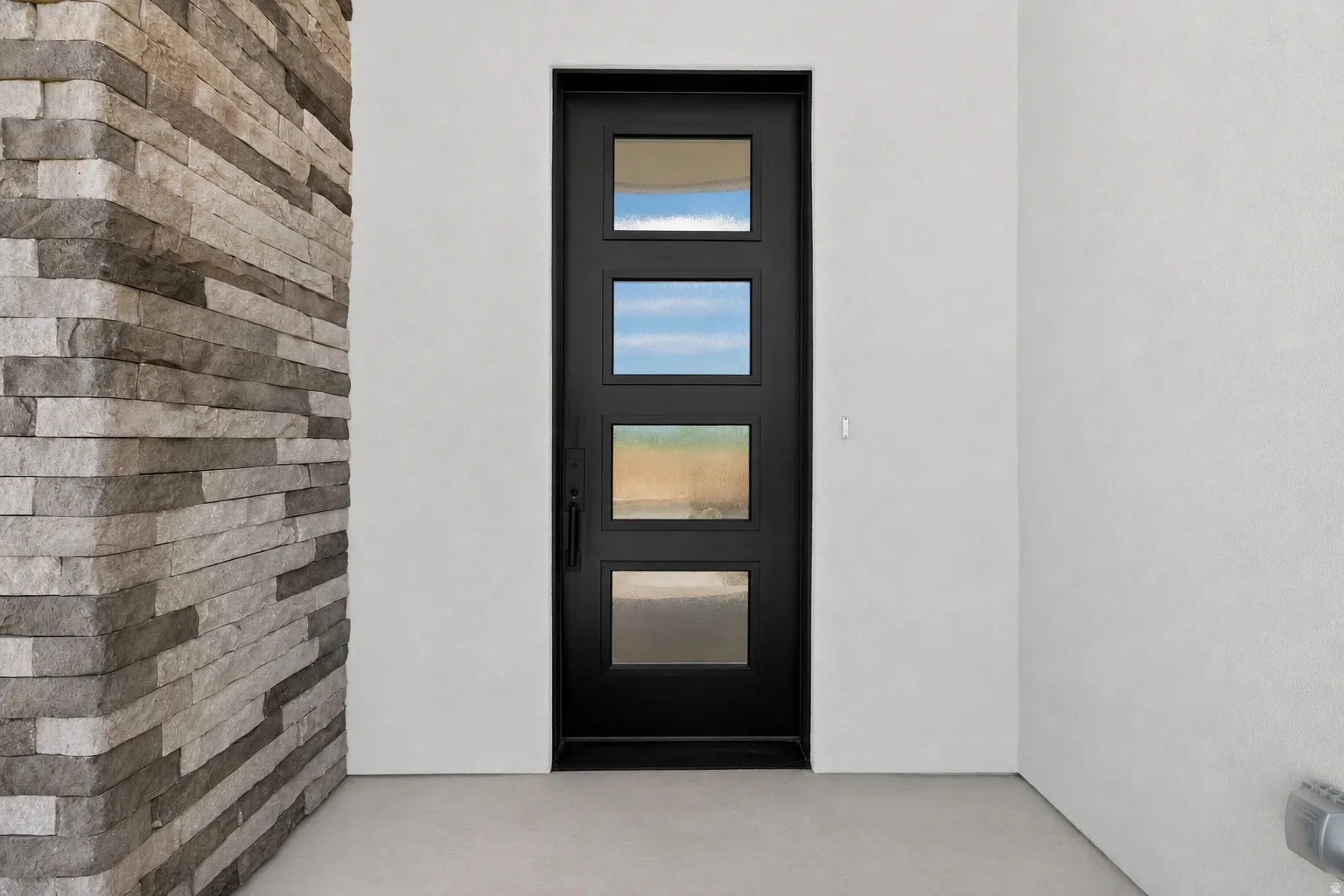 Modern entry door featuring multiple glass panels, contrasting with a stacked stone accent wall