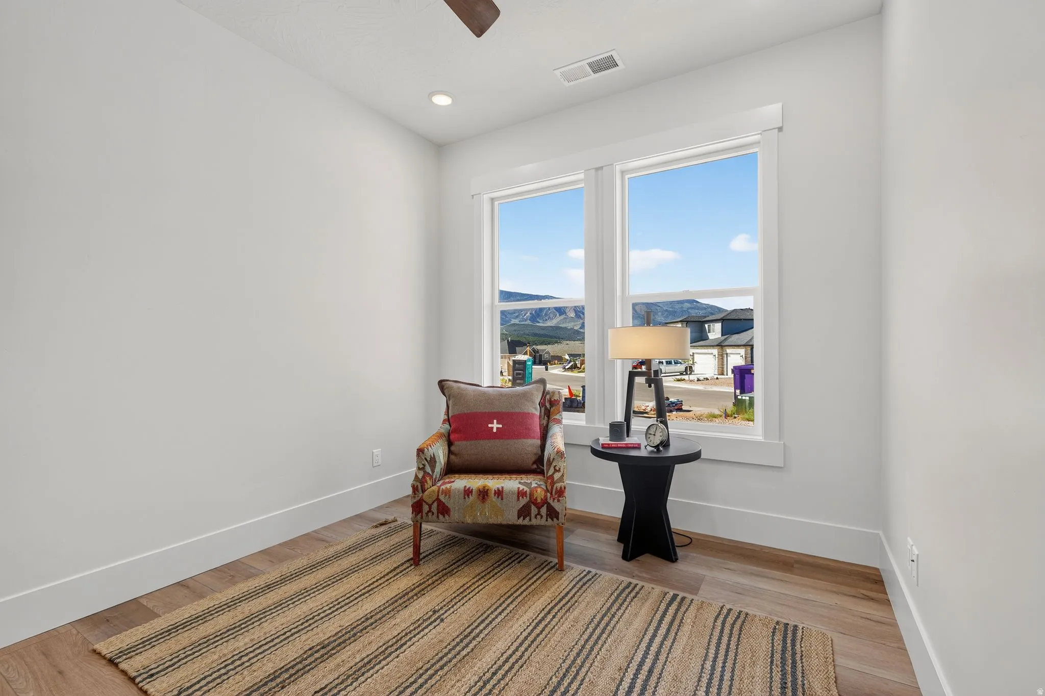 Room featuring light wood-finish flooring, white baseboards, and a white ceiling with recessed lighting
