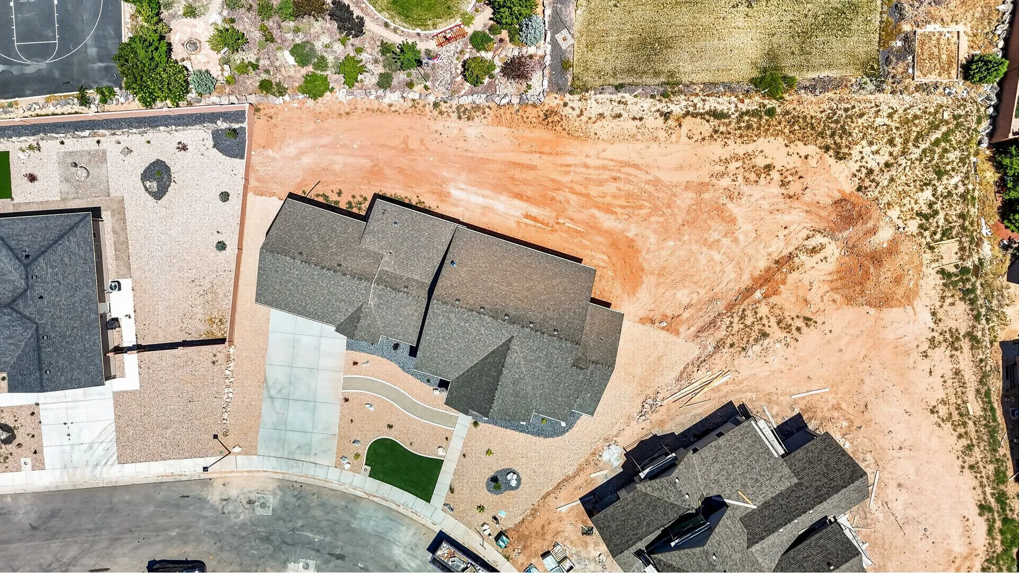 Newly constructed residence featuring a multi-gabled roofline and an expansive front driveway