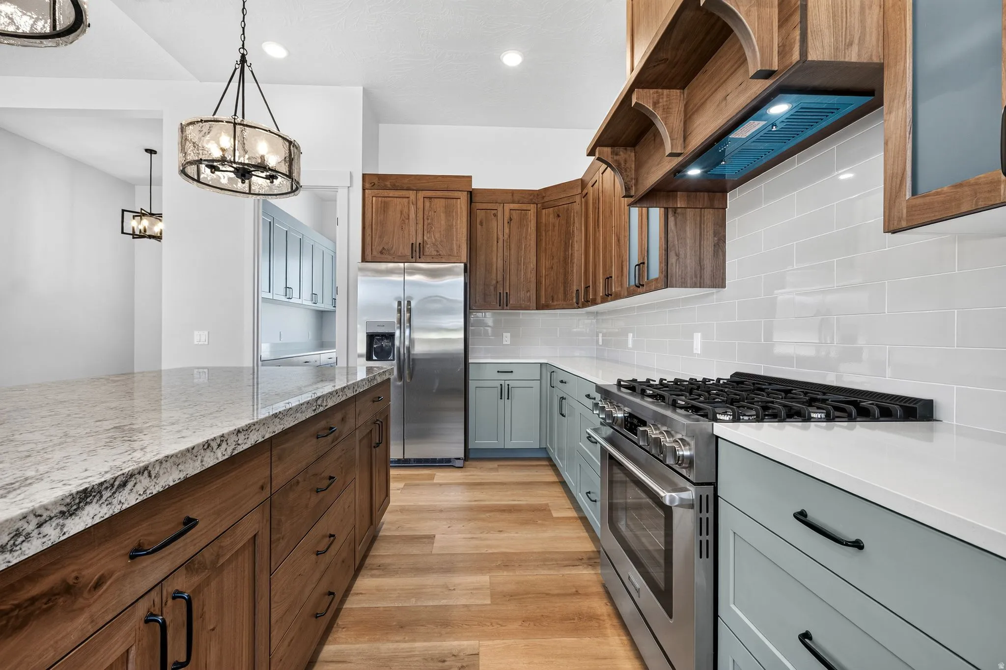 Kitchen featuring two-tone cabinetry, light-toned countertops, and laminate flooring