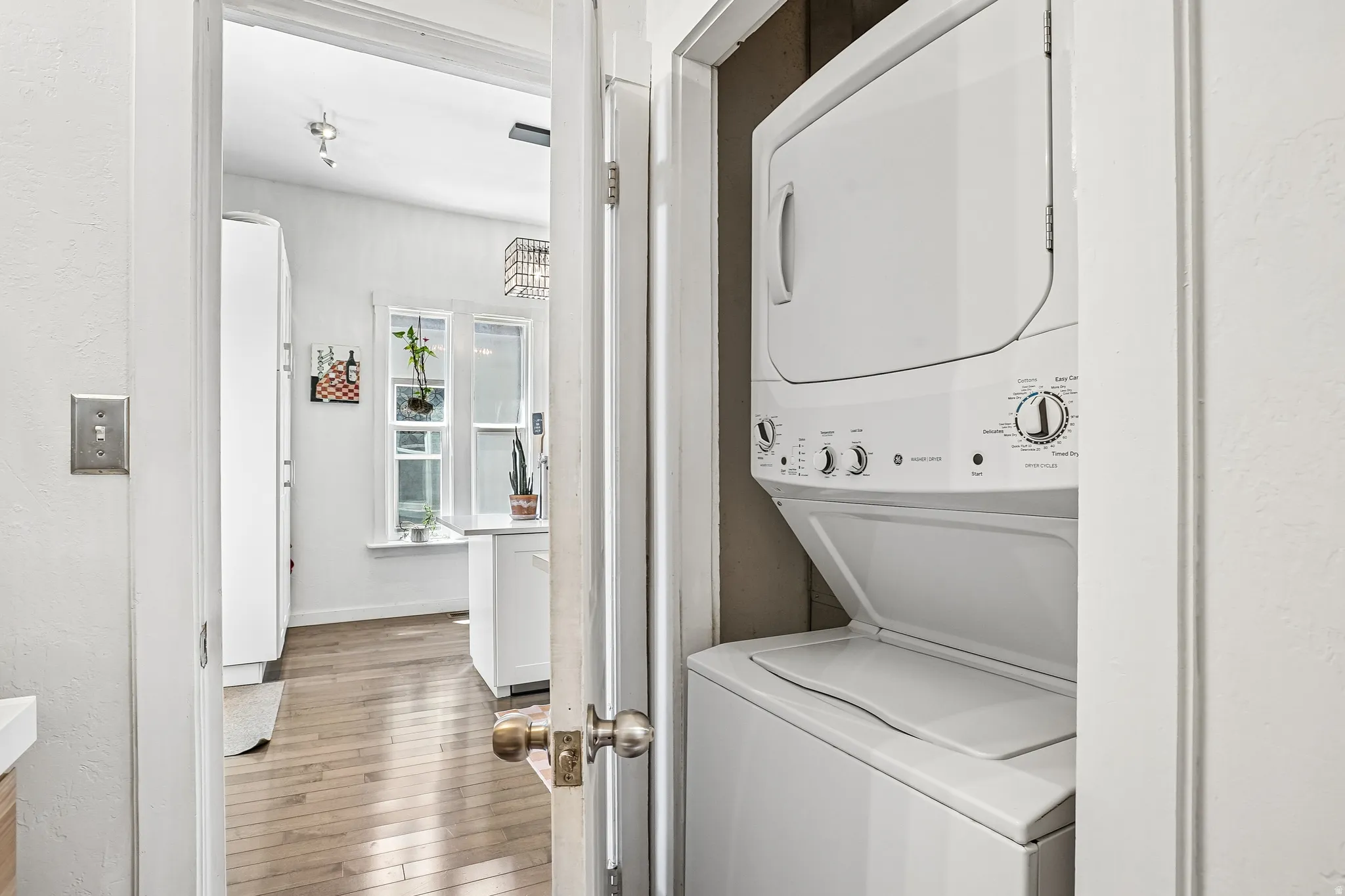 Dedicated laundry closet featuring a white stackable washer and dryer unit