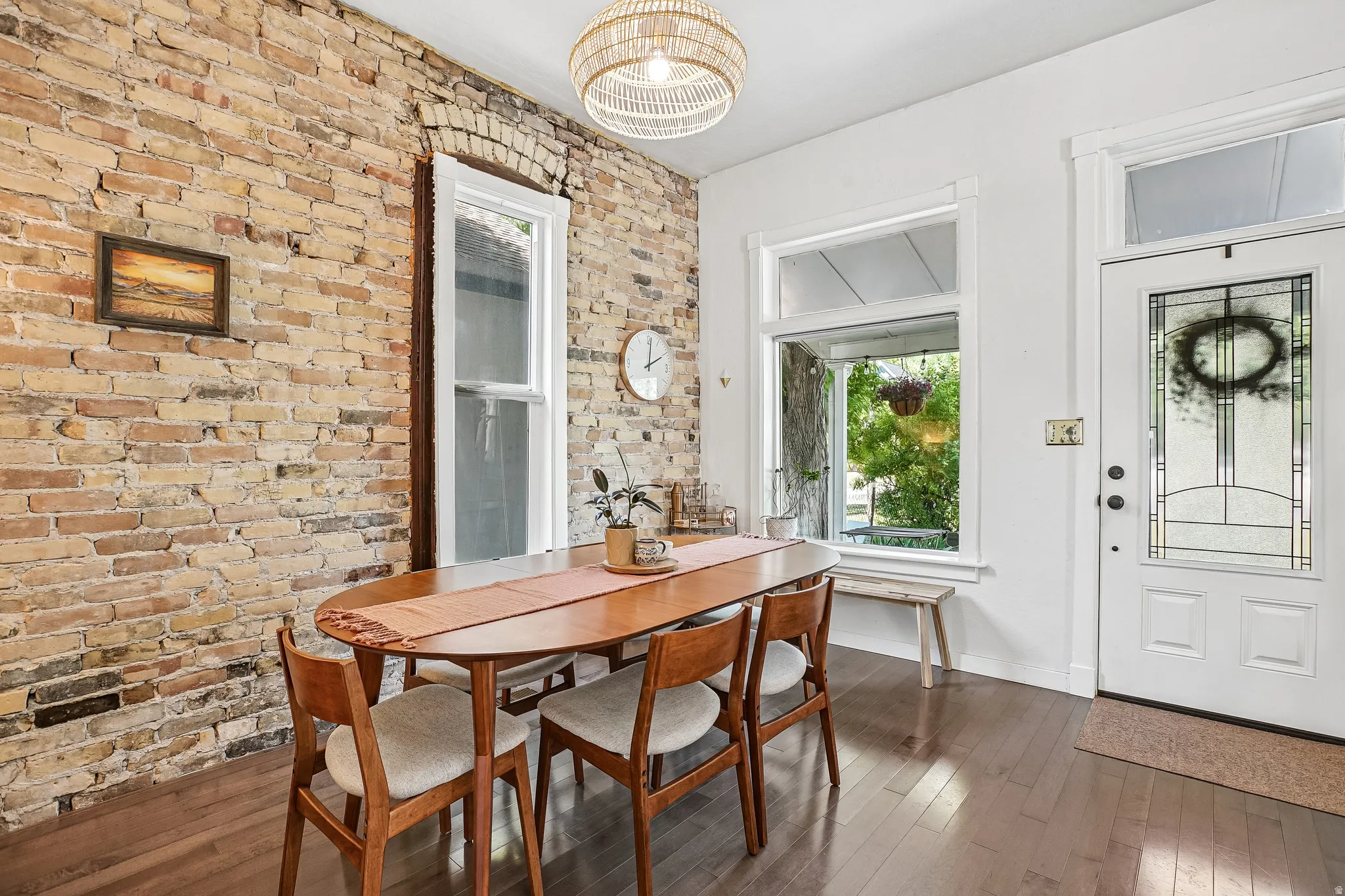 Exposed brick wall featuring a window with an arched lintel