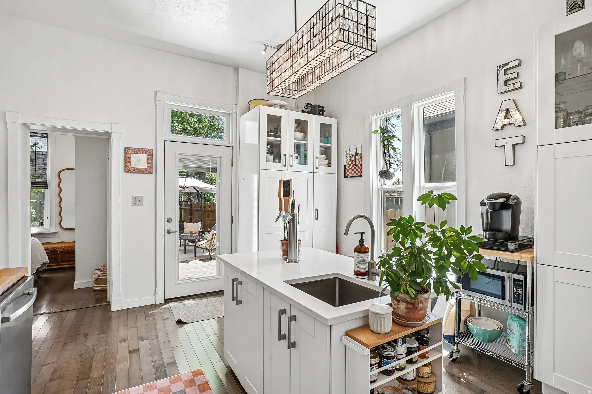 Kitchen featuring an expansive center island with an undermount sink and gooseneck faucet