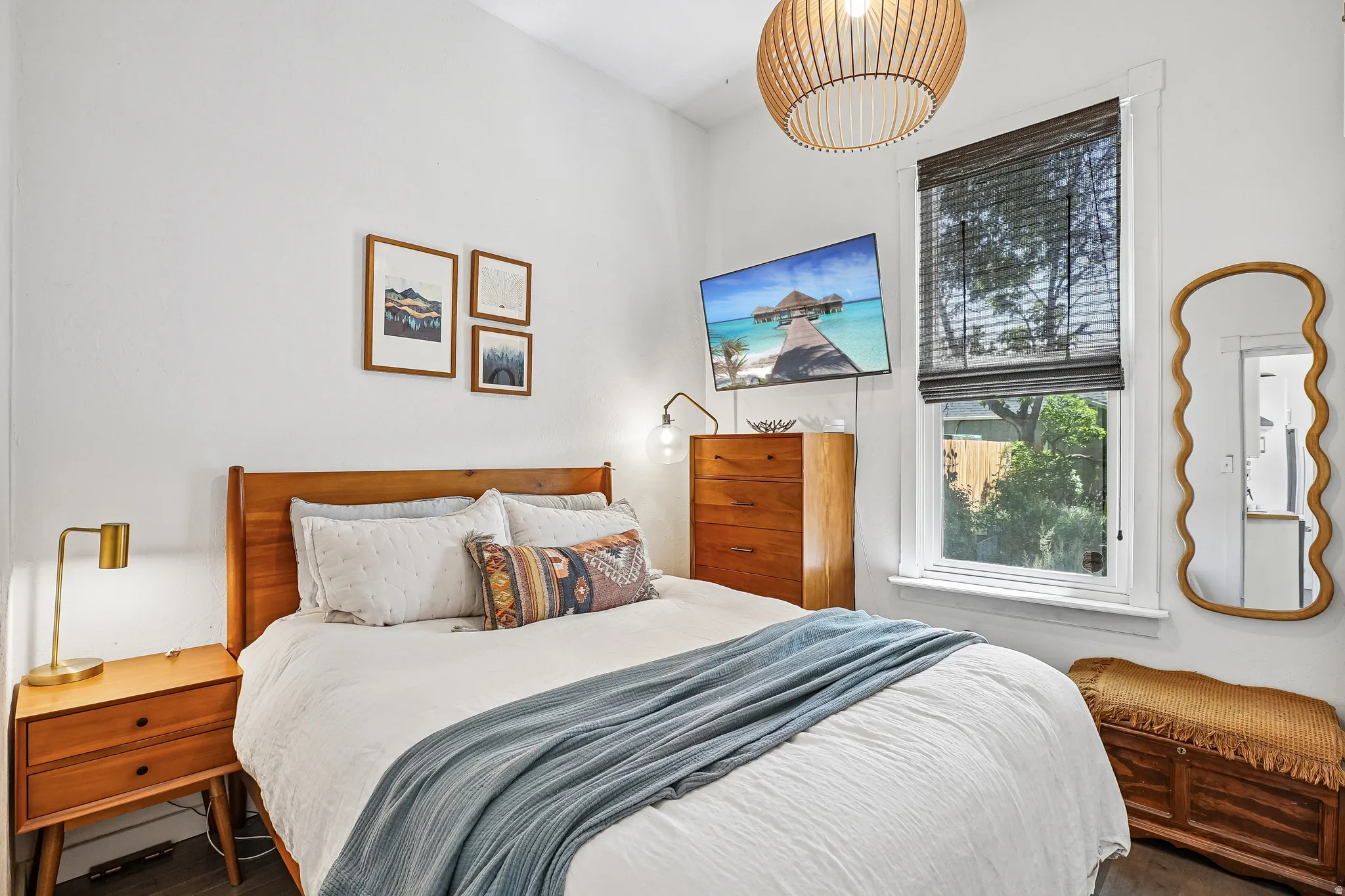 Interior room featuring dark wood-finish flooring, white walls, and a large window with privacy blinds