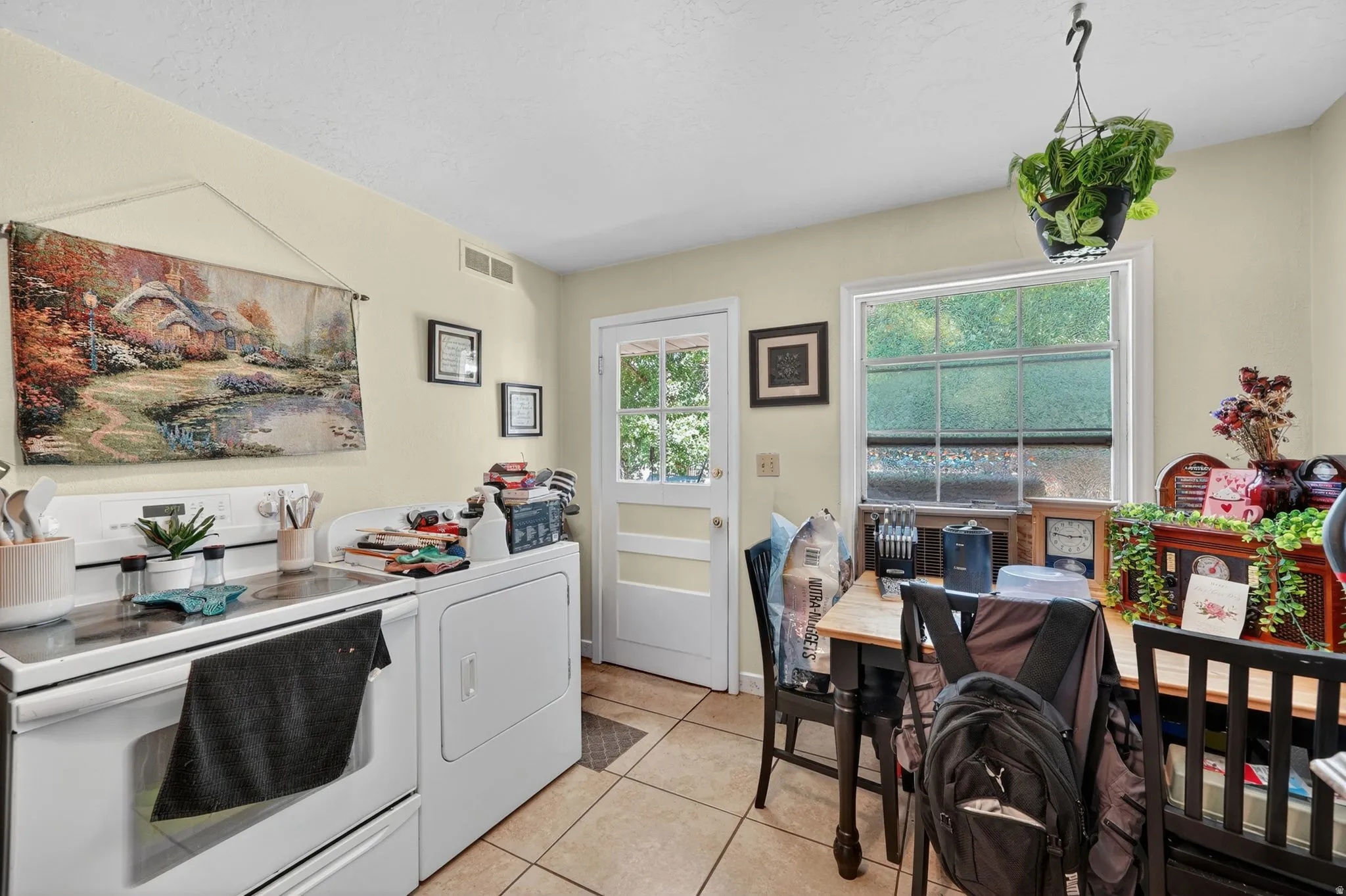 Kitchen with light-toned walls, tile flooring, and a white paneled door with glass inserts