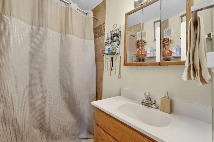 Bathroom vanity with an integrated sink, polished chrome faucet, and wood-finish cabinetry