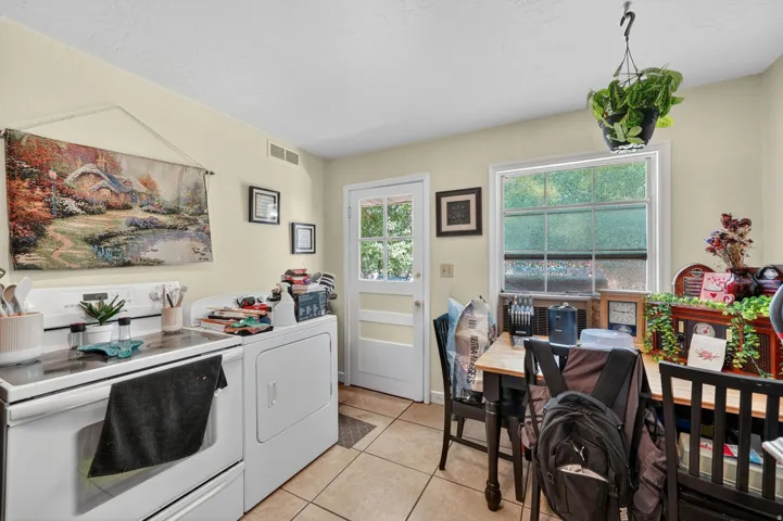 Kitchen with light-toned walls, tile flooring, and a white paneled door with glass inserts