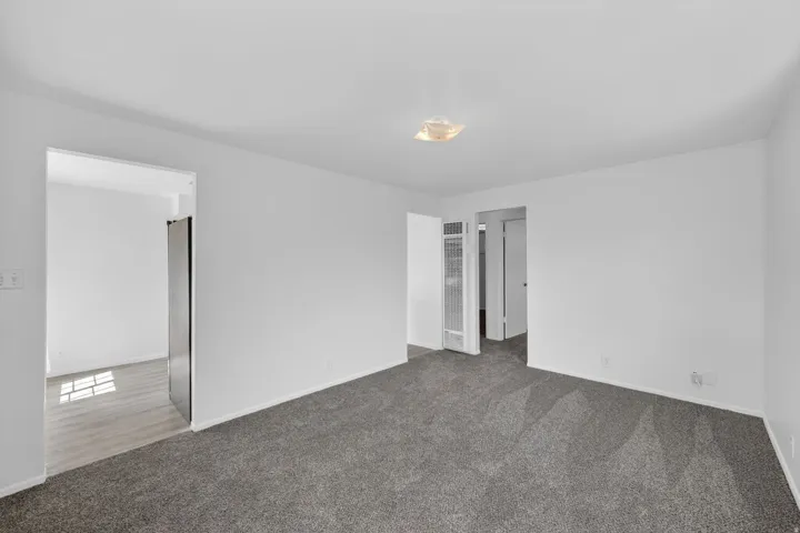 Spacious room featuring gray carpet flooring and white painted walls