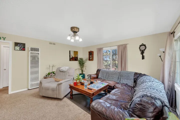 Carpeted living space featuring a ceiling-mounted light fixture and a wall-mounted heater
