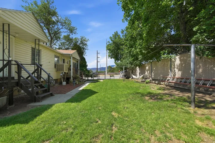 Expansive lawn area with a concrete pathway and mature trees